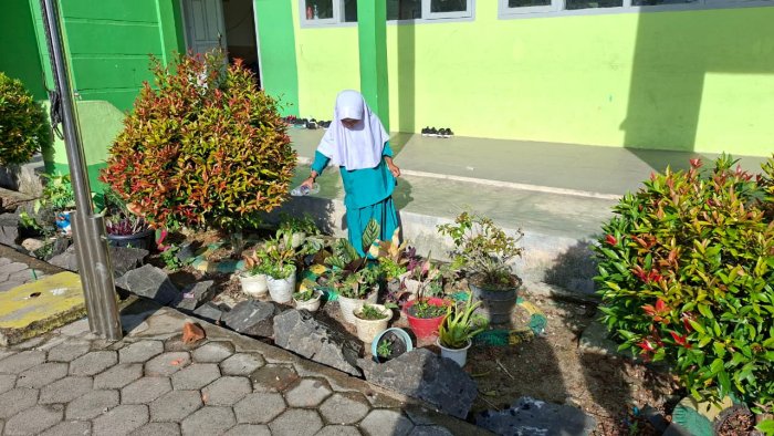 Siswa Kelas I B MIN 4 Batang Hari Menyiram Tanaman di Depan Kelas
