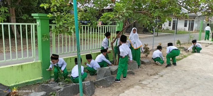 Siswa Kelas I MIN 4 Batang Hari Bekerja Sama Membersihkan Halaman Madrasah