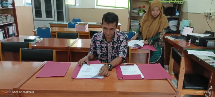 Staf TU Hendrik Pratama Mengecek Bahan Kenaikan Pangkat Guru Staf TU Hendrik Pratama Mengecek Bahan Kenaikan Pangkat Guru