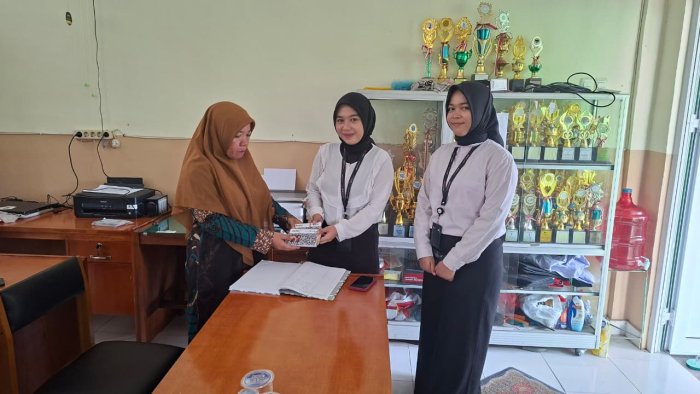 Petugas Bank 9 Jambi Hayuning Sholatin Serahkan Buku Tabungan Siswa kepada Wali Kelas I A MIN 4 Batang Hari