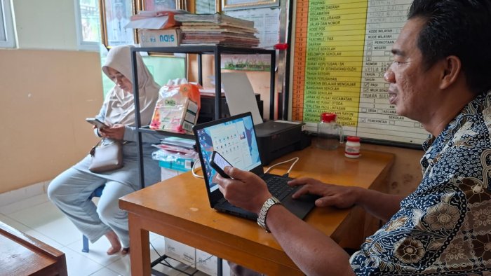 Staf TU Yusuf Memberikan Surat Pernyataan Tes Kemampuan Akademik kepada Orang Tua Siswa