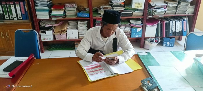 Staf TU Ramlan Lakukan Pengecekan Absensi Manual